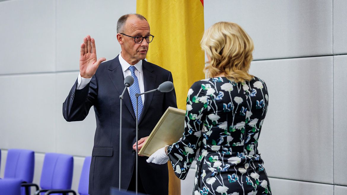 Bundestagspräsidentin Julia Klöckner (rechts) nimmt Bundeskanzler Friedrich Merz (links) den Amtseid ab. Friedrich Merz steht mit erhobener Hand vor Julia Klöckner und schwört den Amtseid