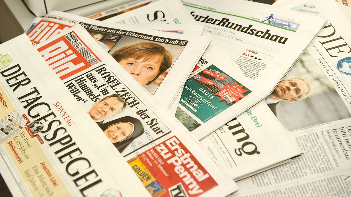 The Press Documentation Division monitors, indexes and archives the newspapers. Illustration of many German daily newspapers on a pile